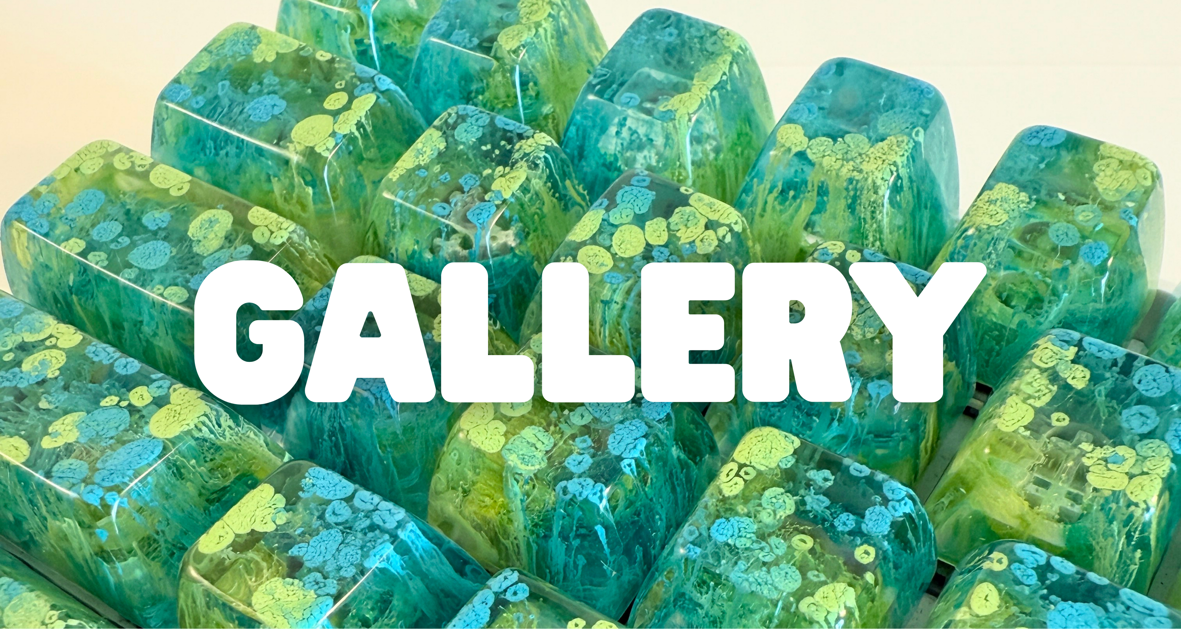 The word "gallery" overlaid on green and blue resin artisan keycaps